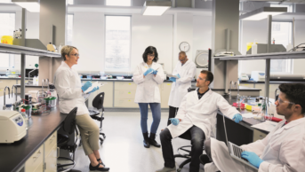 Professor speaks with students in a laboratory