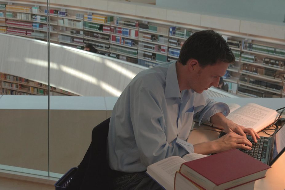 Researcher writing a literature review in a library