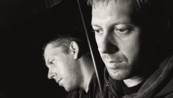 Patients with a first episode of psychosis should be offered an injection of a long-acting antipsychotic rather than just oral medication. In the image, a sad, depressed man and his reflection