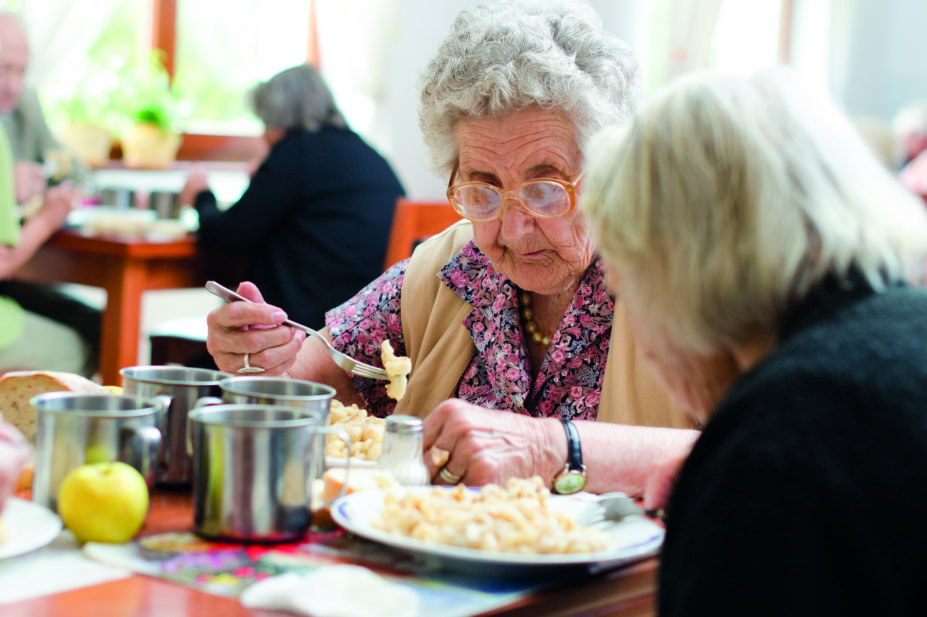 Senior woman eating in a care home