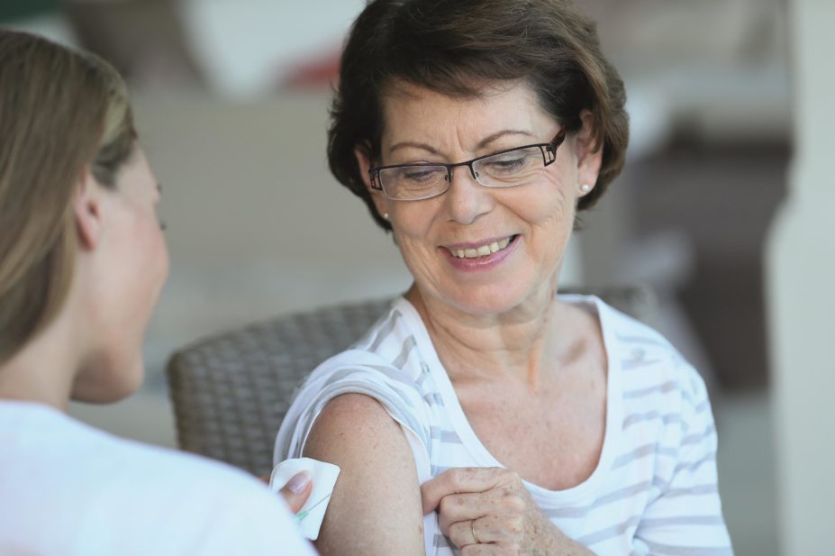 Customers using a pharmacy vaccination service are happy for the pharmacist to be allowed access to their GP records, suggests a survey of over 7,000 patients. In the image, a senior woman is vaccinated by a pharmacist