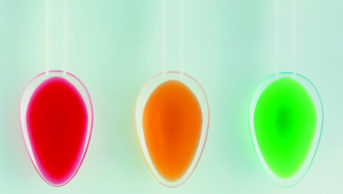 Spoons of red, yellow and green medicine syrup