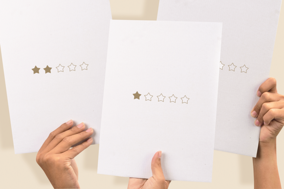 Image of hands holding up sheets of paper with 1-2 star rating