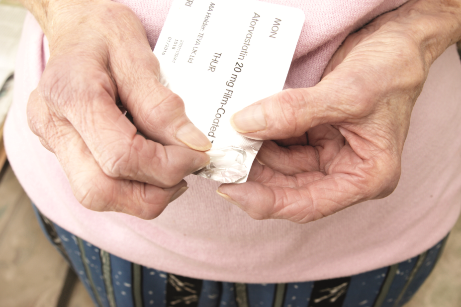 elderly woman taking a statin pill