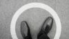 Close up of shoes of a standing man within a white circle