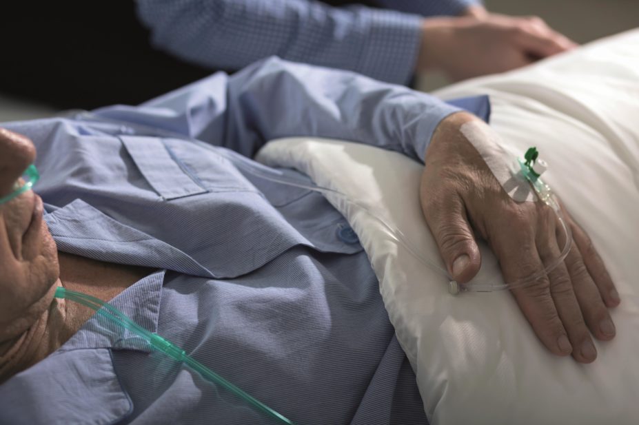 Terminally ill older man in hospital bed