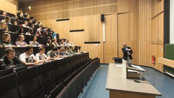 Lecturer in classroom full of students