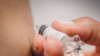Close-up of hand giving vaccination to patient using a syringe