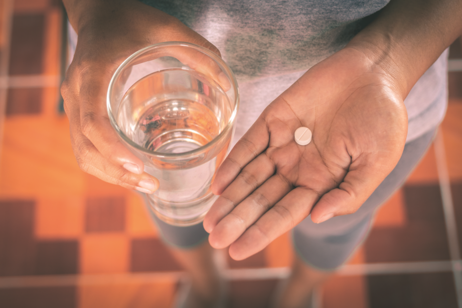 Woman holding paracetamol glass of water