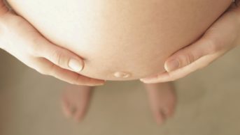 Researchers advise that pregnant women observe current guidelines recommending analgesic use be reserved to the shortest time and the lowest dose possible. In the image, a pregnant woman holds her belly