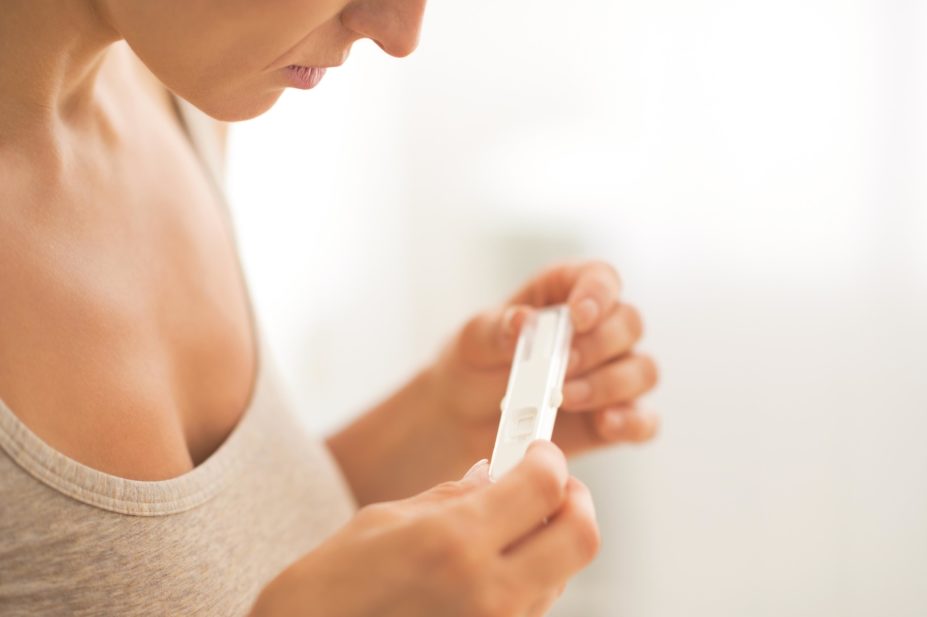 Woman looking at a pregnancy stick test
