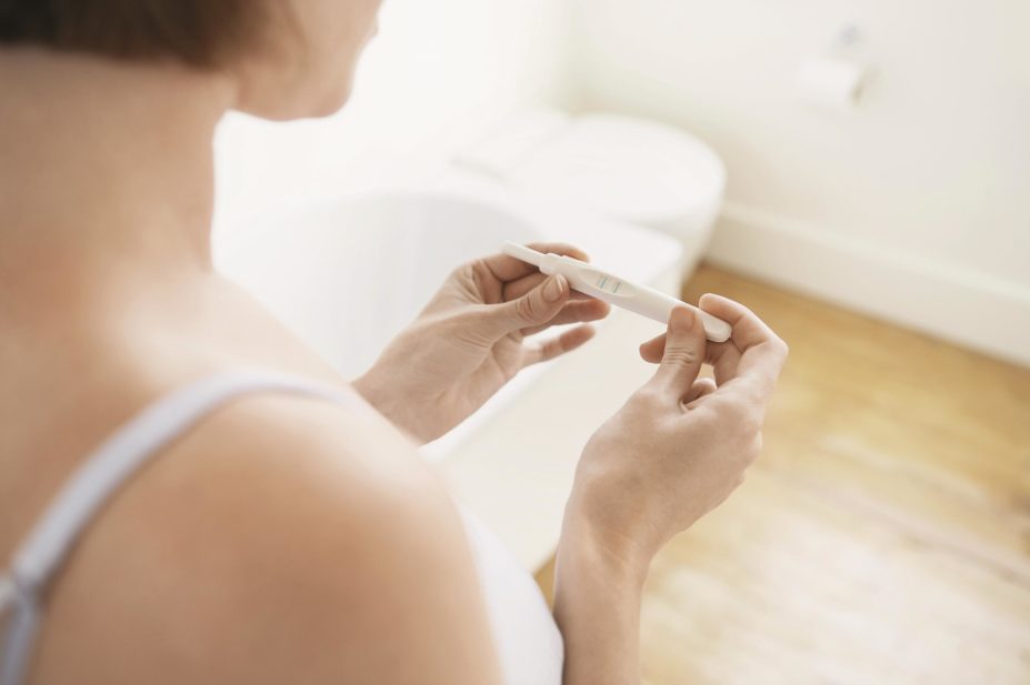 Taking low dose aspirin daily may increase the chance of conception in women with high levels of inflammatory markers, a study finds. In the image, a woman looks at the results of a pregnancy test