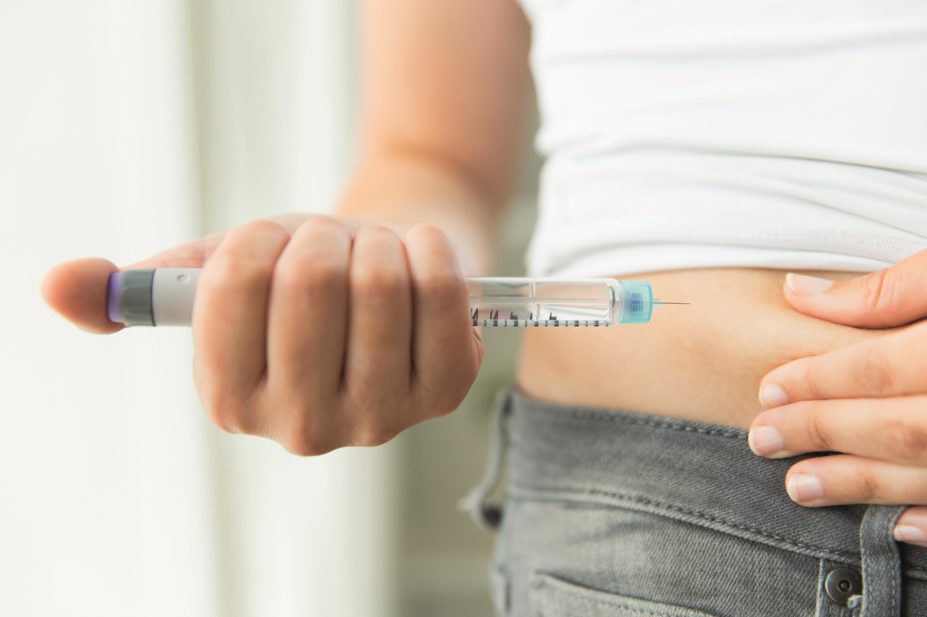 Woman self injecting with insulin