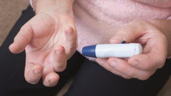 Close-up of a woman's hand as she tests for high blood sugar levels