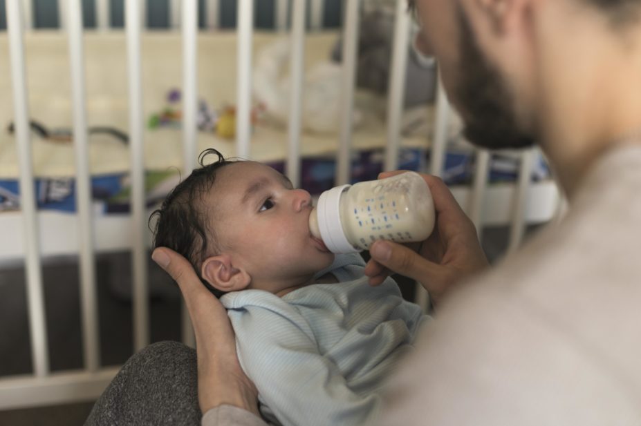Young baby drinking from bottle