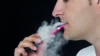Some e-cigarettes and refill liquids contain the flavouring chemical diacetyl which has been linked to cases of the severe respiratory disease bronchiolitis obliterans, according to research. In the image, close-up of a man smoking an e-cigarette