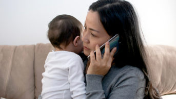 Mother on phone while holding baby