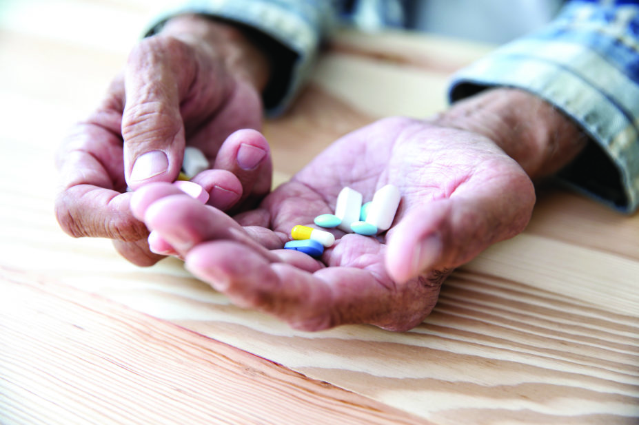 Elderly patient holding medicines
