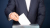 A man putting his vote into a ballot box