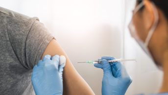 Person administering COVID-19 vaccine