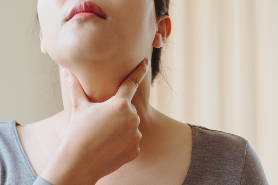 Woman feeling her thyroid gland