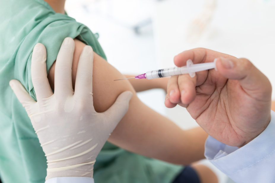 Pharmacist administering a flu vaccine in a patient's arm
