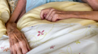 frail female patient lying in bed