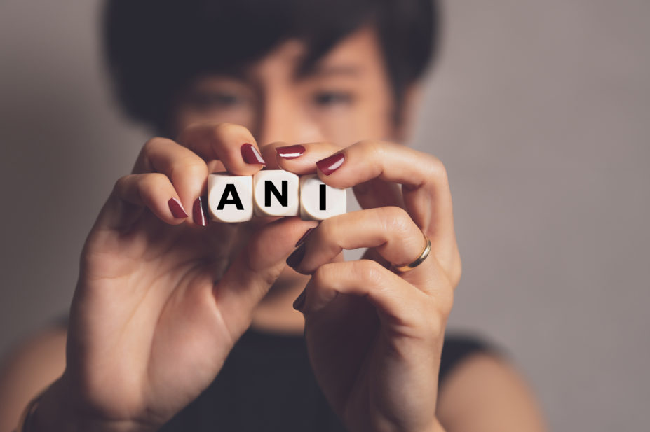 woman holding dice spelling ANI