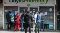 People queuing outside a LloydsPharmacy in Tottenham, north London