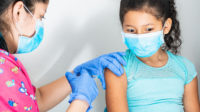 woman vaccinating young girl