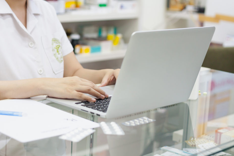 Laptop being used by a pharmacist in a pharmacy