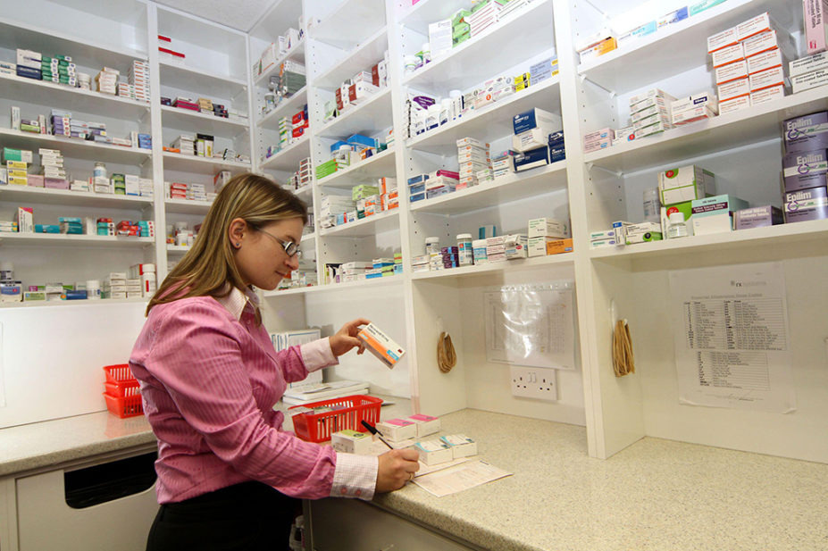 A pharmacist working in a pharmacy on Millport, Isle of Cumbrae, Scotland