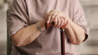 female hands holding a walking stick