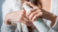 Woman applying oestrogen gel on her hands