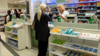 woman speaking to pharmacist at pharmacy counter