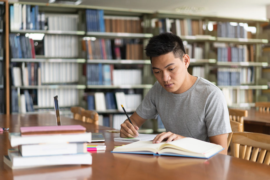 Student studying and reading book in library
