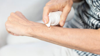 older woman applying oestrogen gel