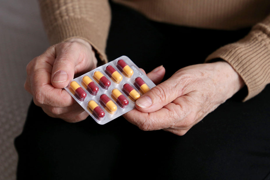 older woman holding antibiotic blister pack