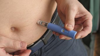 Man injecting medication into belly