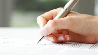 Woman's hand with pen completing form