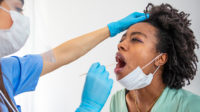 Nurse carrying out cheek swab on patient