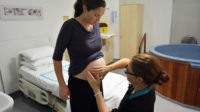 Pregnant woman being checked by midwife