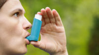 Photo of a woman using a metered dose inhaler