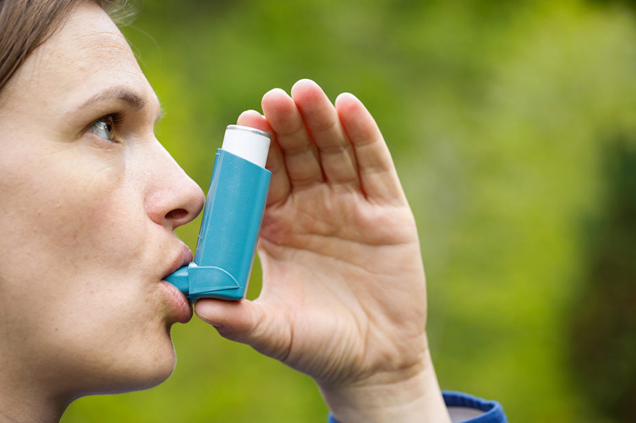 Photo of a woman using a metered dose inhaler