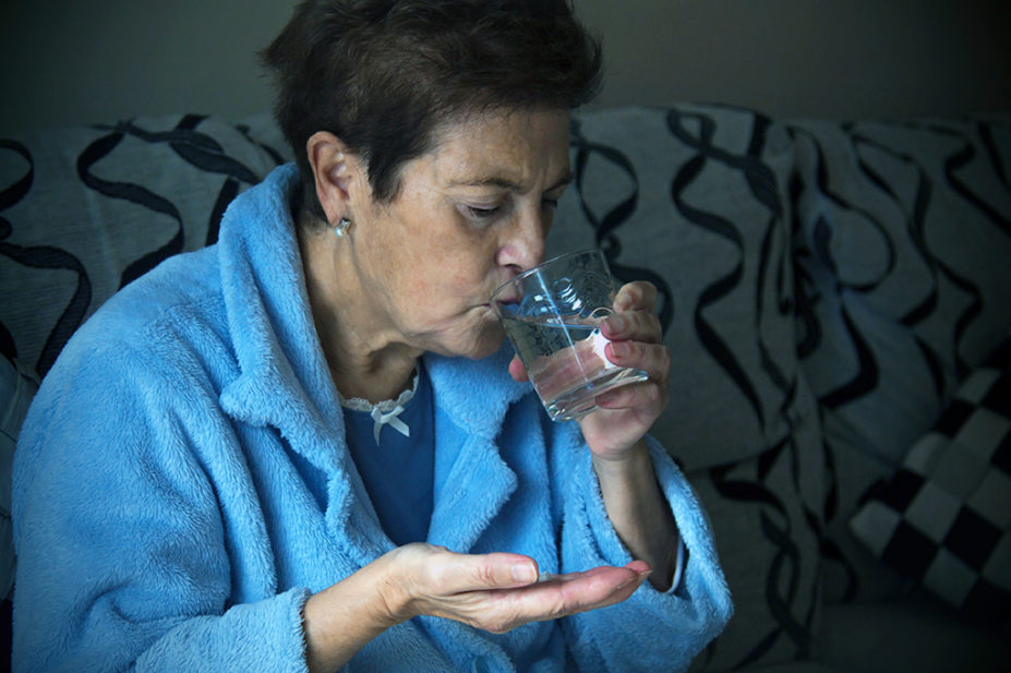 Older woman taking HRT medicine