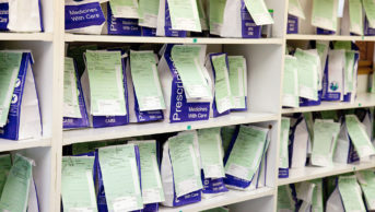 NHS prescriptions on a shelf in pharmacy dispensary