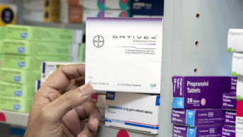 Pharmacist holding a box containing Sativex