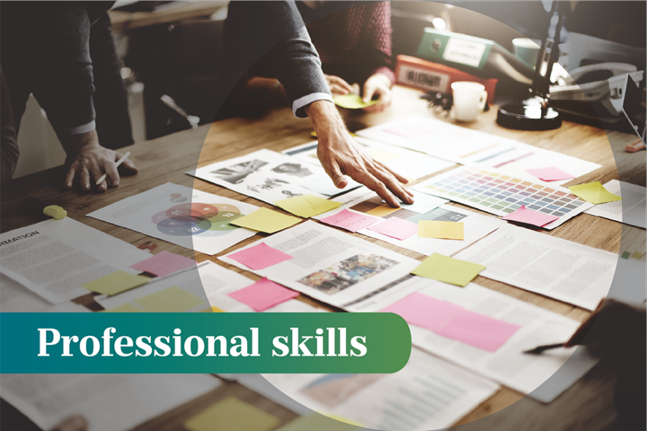 A person leans over a table with lots of papers and sticky notes arranged across, the words 