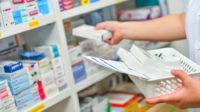 pharmacist filling medicine shelf