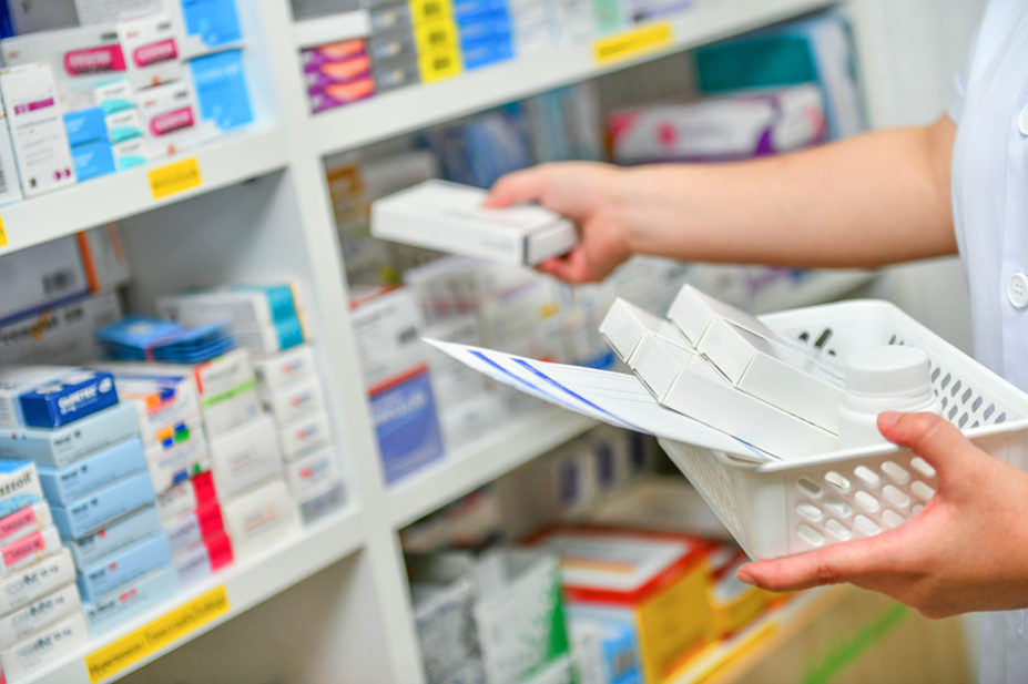 pharmacist filling medicine shelf